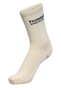 Beige bomuldsstrømpe med ribbet tekstur, der har et sort "hummel SPORTSWEAR" logo strikket nær toppen. Standard strømpeform med forstærket hæl.