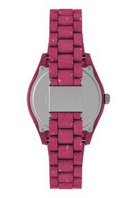 Reloj Timex con una vibrante correa de material reciclado rosa con un acabado texturizado, fondo de acero inoxidable y una hebilla plateada.