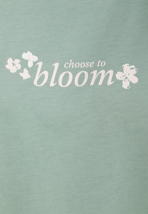 Lichtgroene katoenen T-shirt met witte tekst "choose to bloom" en bloemontwerpen. Gladde textuur, ronde hals, casual stijl.