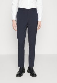 Morski srajčno krojeni hlače s slim fit rezom, z ravnim sprednjim delom, zankami za pas in zapiranjem na en gumb, v kombinaciji z črnimi usnjenimi čevlji.
