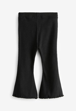 Svarta ribbade flare leggings med en scallopad fåll, tillverkade av mjukt material med resår i midjan för komfort och en figurnära silhuett.
