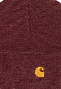 Bordowy czapka beanie wykonana z dzianiny. Posiada żółte haftowane logo oraz teksturowany wzór z zwężającym się czubkiem.