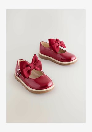 Røde lakerede lædersko med en rund tå, der har en struktureret sløjfe på fronten og en tan gummisål med en sydd kant.