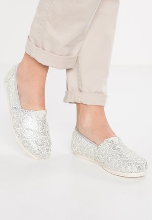 Lys grå slip-on sko med blomsterdækket design og glitrende detaljer. Hvid gummisål, rund tå, med en blød, glat foring.