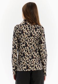 Dlhý rukáv tričko s čiernym, béžovým a burgundským abstraktným leopardím vzorom. Mäkká, hladká tkanina s priliehavým strihom.