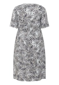 Robe à manches courtes en tissu léger, présentant un motif de feuilles noir et blanc, avec une coupe décontractée et une texture douce. Vue de dos présentée.