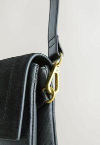 Borsa a spalla in pelle nera con hardware dorato, dotata di una patta testurizzata e di una tracolla elegante. Linee pulite e design minimalista.