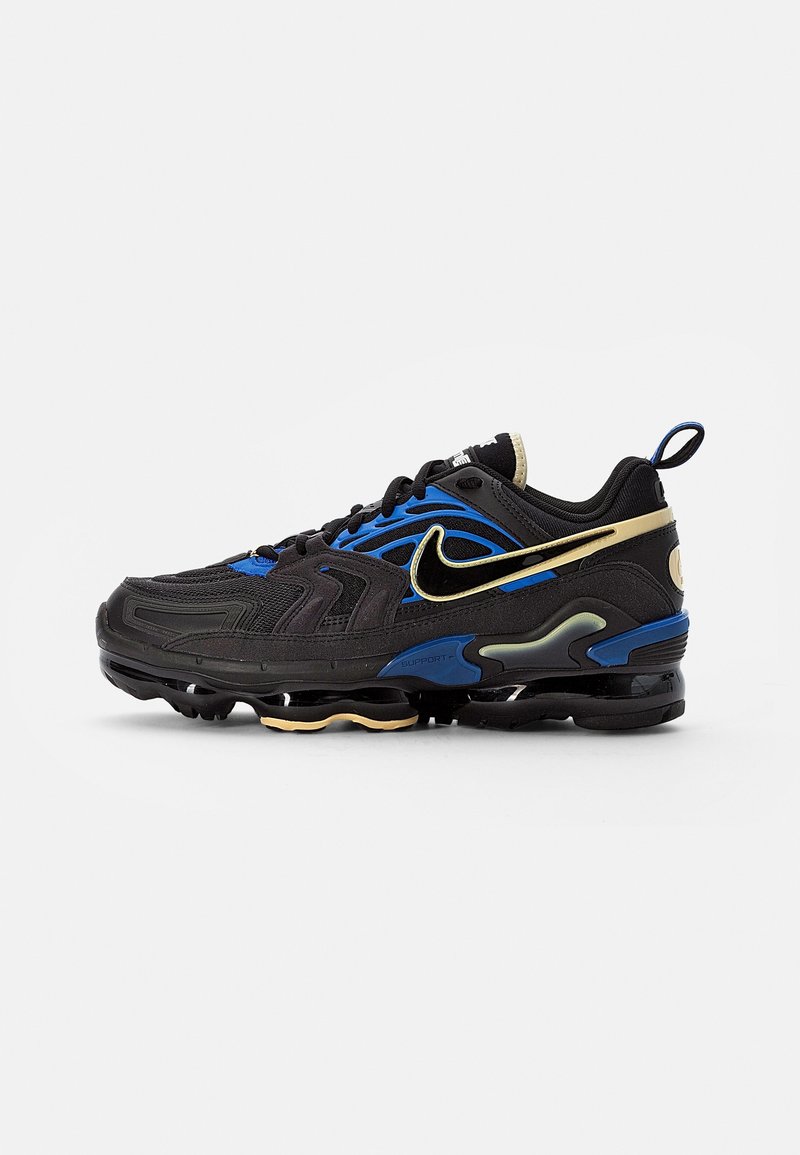 Schwarzer Sportschuh mit blauen und goldenen Akzenten, strukturiertem Obermaterial, markantem wellenförmigem Design und einer gepolsterten Sohle für Unterstützung.