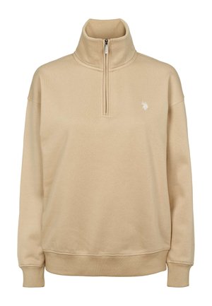 Smėlio spalvos vilnonis džemperis su aukštu apykakliu, pusiau užtrauktuku priekyje, siaurintais rankogaliais ir mažyčiu išsiuvinėtu logotipu kairėje krūtinės pusėje.