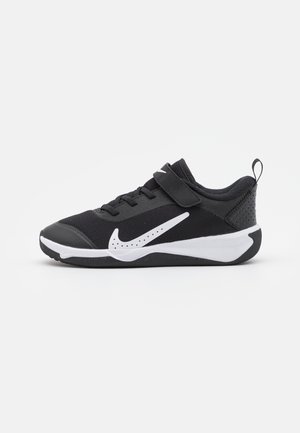 Black athletic shoe with mesh upper, white Nike logo, and Velcro strap. Features a padded collar and durable rubber sole.