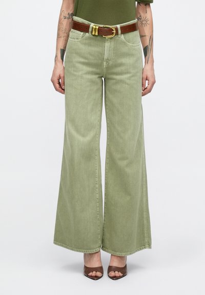Jean vert à jambes larges en denim, doté d'une ceinture en cuir marron avec une boucle dorée, texture lisse et bords bruts.