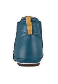 Teal läderankelboot med en guldslinga baktill, slät yta, rund form och brun sula. Särskild sömnadsdetalj finns.