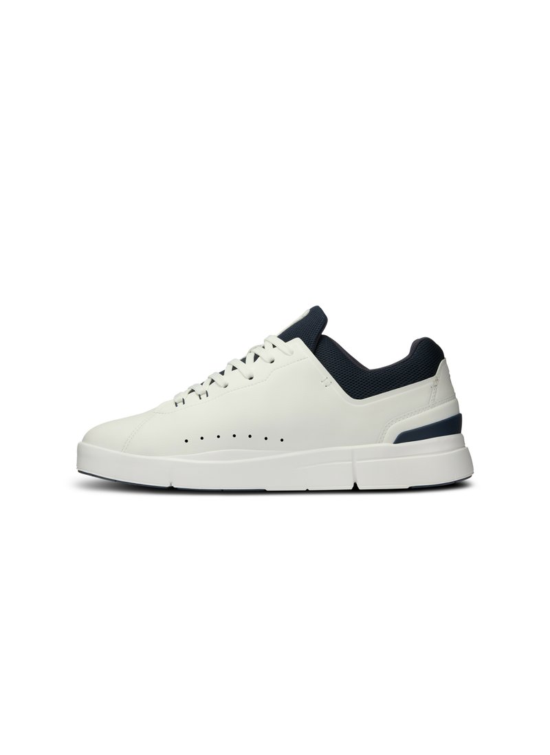Sneaker bianco in pelle con collare in rete blu navy, design curvo, dettagli perforati sui lati e una spessa suola bianca con accenti blu navy.