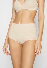 Beige høy midje undertøy med en glatt tekstur, elastisk midjebånd og full dekning design. Ingen synlige mønstre eller hardware detaljer.