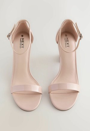 Nude högklackade sandaler med glänsande yta, med ett brett framrem, ankelspänne och mjukt lädermaterial. Märke: NEXT.