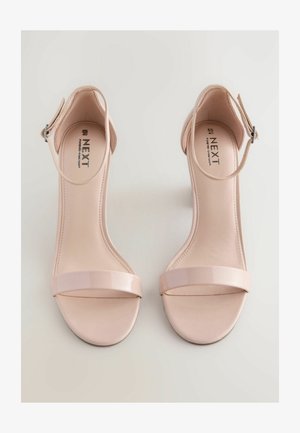 Nude hoge hakken sandalen met een glanzende afwerking, voorzien van een brede voorband, enkelgesp en een gladde leren textuur. Merk: NEXT.
