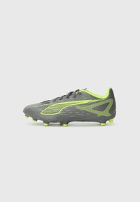 Grey soccer cleat with a textured upper, featuring neon green accents and studs. Streamlined design with a lace-up closure.