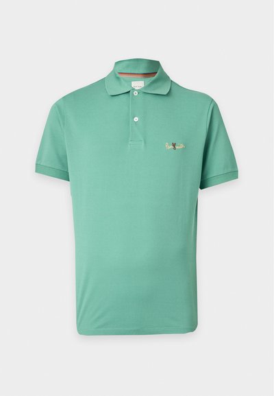 Polo vert à manches courtes avec deux boutons blancs et un petit texte brodé orange sur la poitrine gauche.