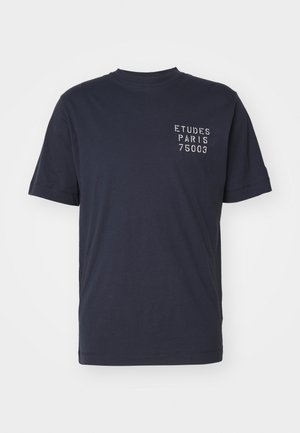 Granatowy t-shirt z krótkim rękawem, okrągłym dekoltem i białym napisem "ETUDES PARIS 75003" na lewej piersi.