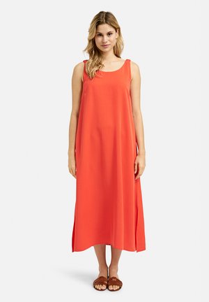 Maxikleid in hellkorallenfarben, aus glattem Stoff, mit Rundhalsausschnitt und Seitenschlitzen. Kombiniert mit braunen flachen Sandalen.
