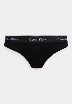 Čierne bavlnené tangá s plochým pásom a bielym logom "Calvin Klein". Hladká textúra a minimalistický dizajn.