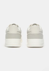 Šedé tenisky s hladkým syntetickým svrškem, bílými podrážkami, polstrovaným límcem a tkaničkami. Zaoblený podpatek a minimalistický design.