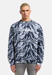 Navy blue sweatshirt with a wavy white pattern, featuring the brand name "Carlo Colucci" in white on the front and ribbed cuffs.