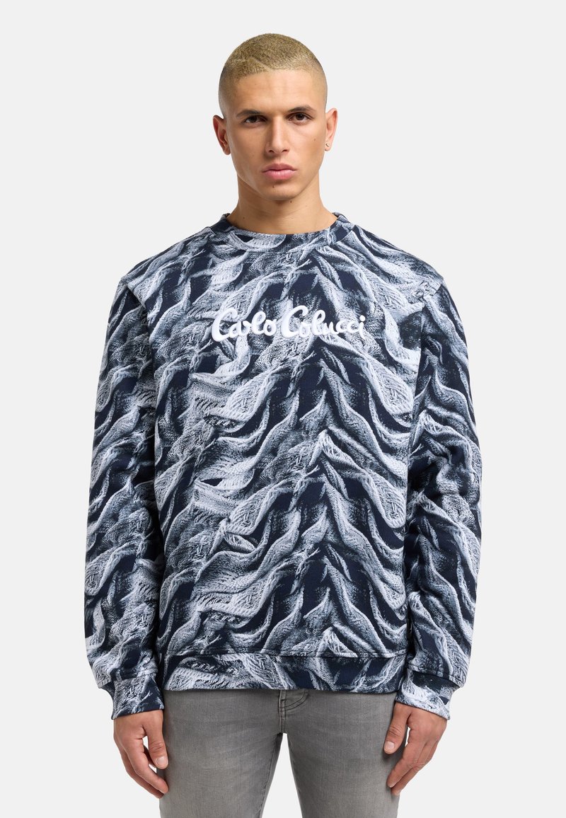 Navy blue sweatshirt with a wavy white pattern, featuring the brand name "Carlo Colucci" in white on the front and ribbed cuffs.