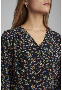 Robe à imprimé floral bleu marine avec de petits motifs multicolores, encolure en V et trois boutons de différentes couleurs. Tissu texturé avec une légère brillance.