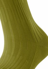 Olivgrüne Socke mit gerippter Textur und glatter Oberfläche, die subtile Wellenmuster sowie verstärkte Zehen- und Fersenbereiche aufweist.