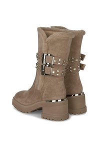 Botas de tobillo de ante beige con forro esponjoso, correas de doble hebilla adornadas con tachuelas y tacones de bloque texturizados y resistentes.