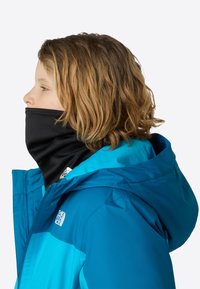 Chaqueta con capucha azul y negra con cuello alto, cierre de cremallera y detalle de logotipo. Material suave y liso con un acento de tela texturizada.