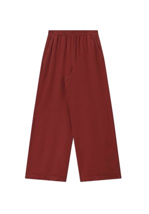 Pantalon à jambes larges couleur rouille avec ceinture élastique et poches latérales, présenté à plat sur fond blanc.