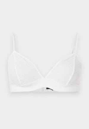 Λευκό ριμπ τριγωνικό σουτιέν με λεπτές ρυθμιζόμενες τιράντες και ελαστική ταινία κάτω, σε απλό ανοιχτό γκρι φόντο.