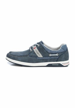 Zapatos casuales en azul marino hechos de cuero y malla, con un panel gris en contraste, suela blanca y detalles decorativos en los cordones.