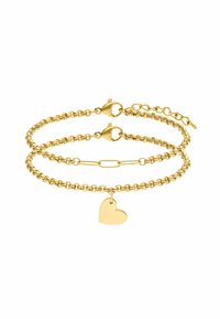 Gouden armband met twee verbonden kettingen, waarvan er één een klein hartje hanger heeft. De kettingen hebben een gladde textuur en veilige sluitingen.