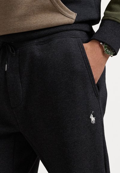 Melnas kapuču jakas ar kangaroo kabatu, ar auklu jostas daļu un mazu balto logo. Mīksta auduma, ar struktūru līdzīgu izskatu.