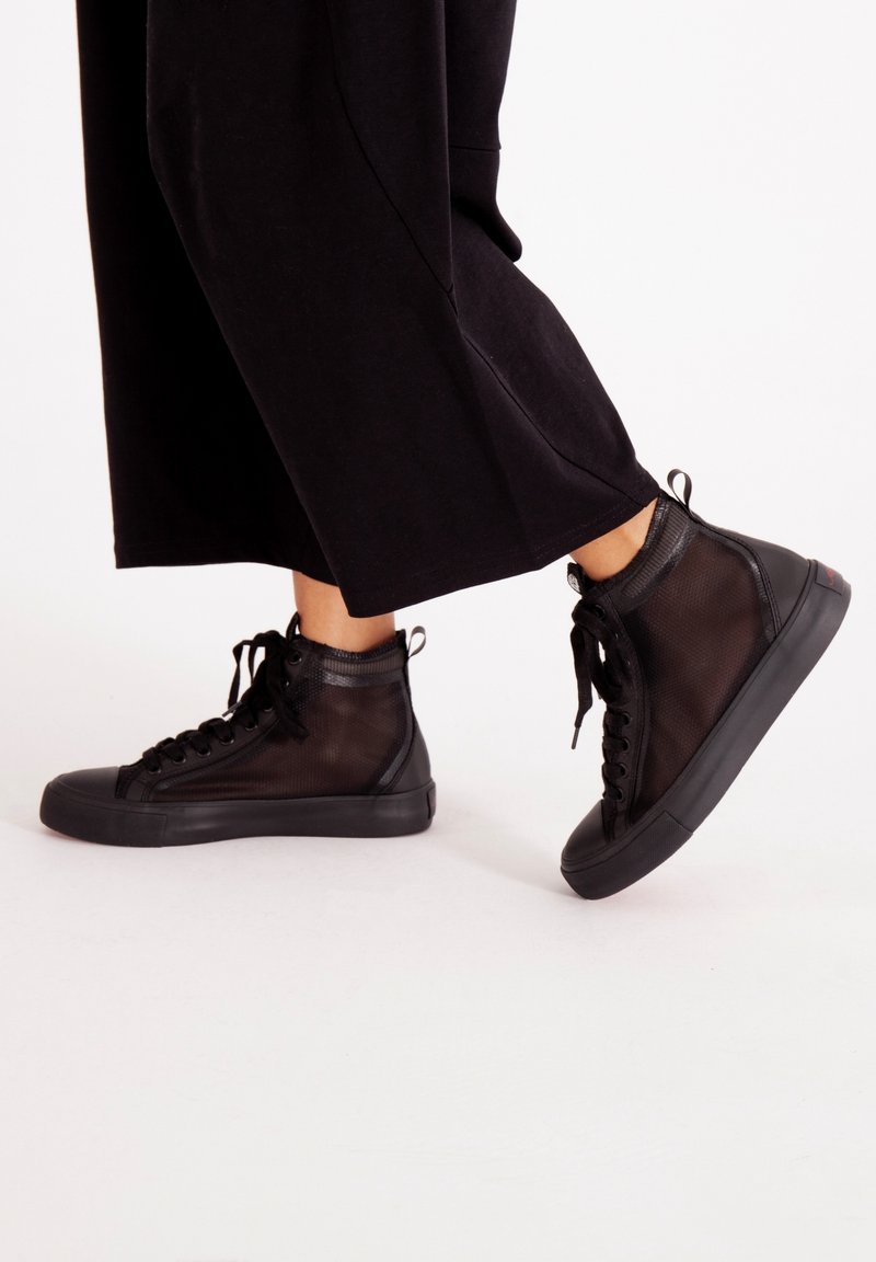 Svarta högskurna sneakers med en meshövre, rund tå och gummisulor med texturerad detalj och snören.