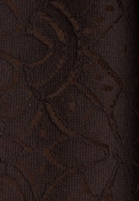 Tissu tissé brun foncé avec un motif de dentelle florale complexe comprenant des pétales et des détails ajourés.