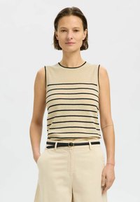 Beige sleeveless top with black horizontal stripes, round neckline, and contrasting black trim, paired with light-colored trousers and belt.