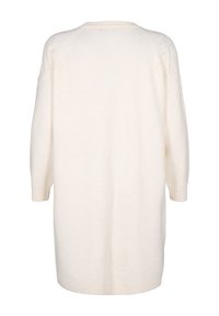 Pitkä, ylisuuressa koossa oleva neulepaita kermaisen värisenä. Valmistettu pehmeästä kankaasta, jossa on hieman teksturoitu pinta. Varustettu raglan-hihalla ja ribbauslohkoilla.