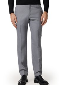 Szare formalne spodnie o dopasowanym kroju, z płaskim przodem i bocznymi kieszeniami, wykonane z gładkiego materiału. Nosi się je z parą czarnych skórzanych eleganckich butów.
