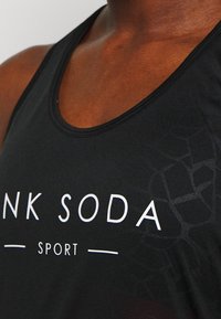 Černý sportovní top s kulatým výstřihem, texturovaným vzorem na boku a bílým potiskem s nápisem "PINK SODA SPORT."