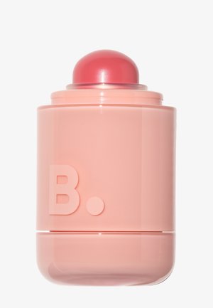 Glänzender pinkfarbener zylindrischer Lippenbalsam mit abgerundetem pinkfarbenem Deckel und einem erhabenen "B." vorne, vor schlichtem hellem Hintergrund.