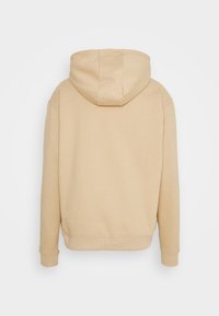 Felpa beige con cappuccio regolabile, polsini e orlo a costine; realizzata in tessuto morbido e testurizzato, presenta un design pulito e minimalista.