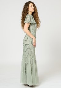 Langes, tailliertes Kleid aus hellgrünem Chiffon mit kunstvollen Paillettenmustern, kurzen, flatternden Ärmeln und einem fließenden Rock.