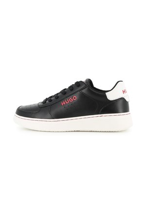 Baskets en cuir noir avec semelle blanche et languette de talon, avec logo rouge "HUGO" sur le côté et à l'arrière, et lacets noirs.