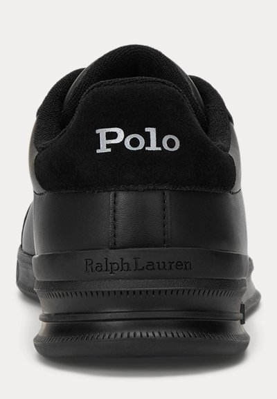 Juoda Polo Ralph Lauren sportbačių kulno dalis su balta išsiuvinėta „Polo“ ir ant pado juostos iškaltu „Ralph Lauren“.