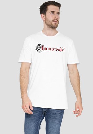 White cotton t-shirt featuring the text "Unconceivable!" in black and red, with a decorative graphic and a relaxed fit design.