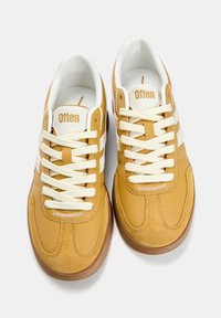 Brązowo-beżowe trampki wykonane ze skóry i zamszu, z białymi sznurówkami i trzema białymi paskami. Logo „Often” na języku.